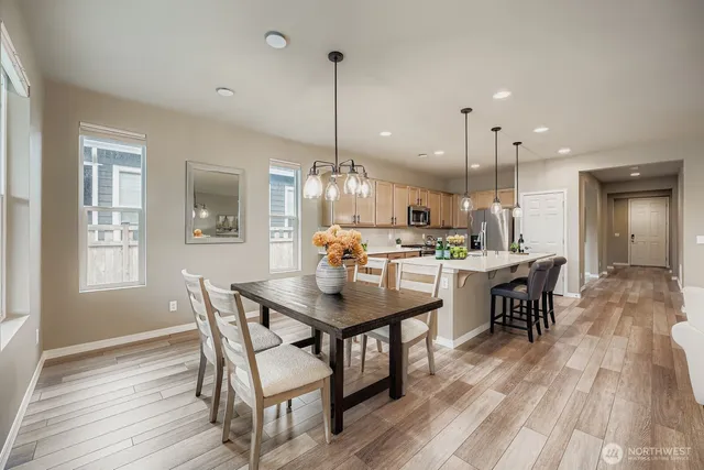 a view of a dining room and livingroom with furniture wooden floor a chandelier