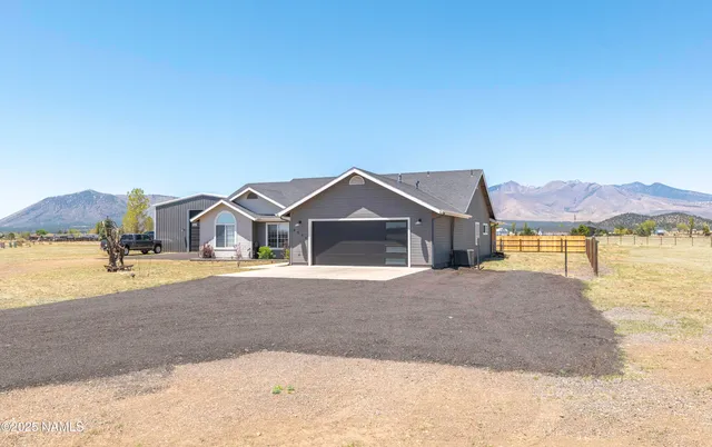 a kitchen with stainless steel appliances a stove top oven a sink dishwasher a dining table and chairs with wooden floor