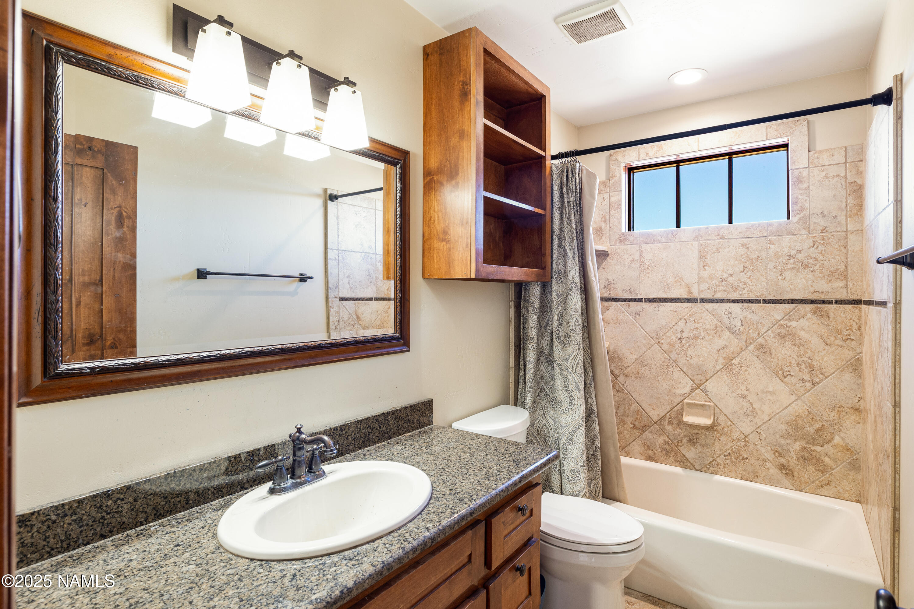5835 Switchback Trail Flagstaff, AZ 86004 - Photo 15 of 35 a bathroom with a sink a toilet and shower a mirror