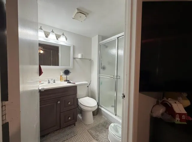 a bathroom with a toilet sink double vanity and mirror