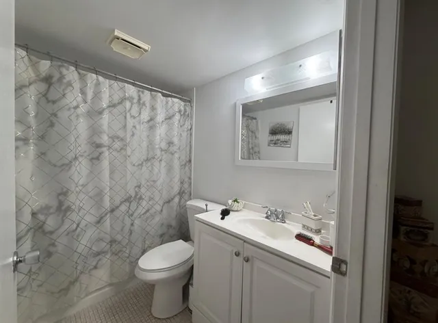 a bathroom with a sink toilet and shower