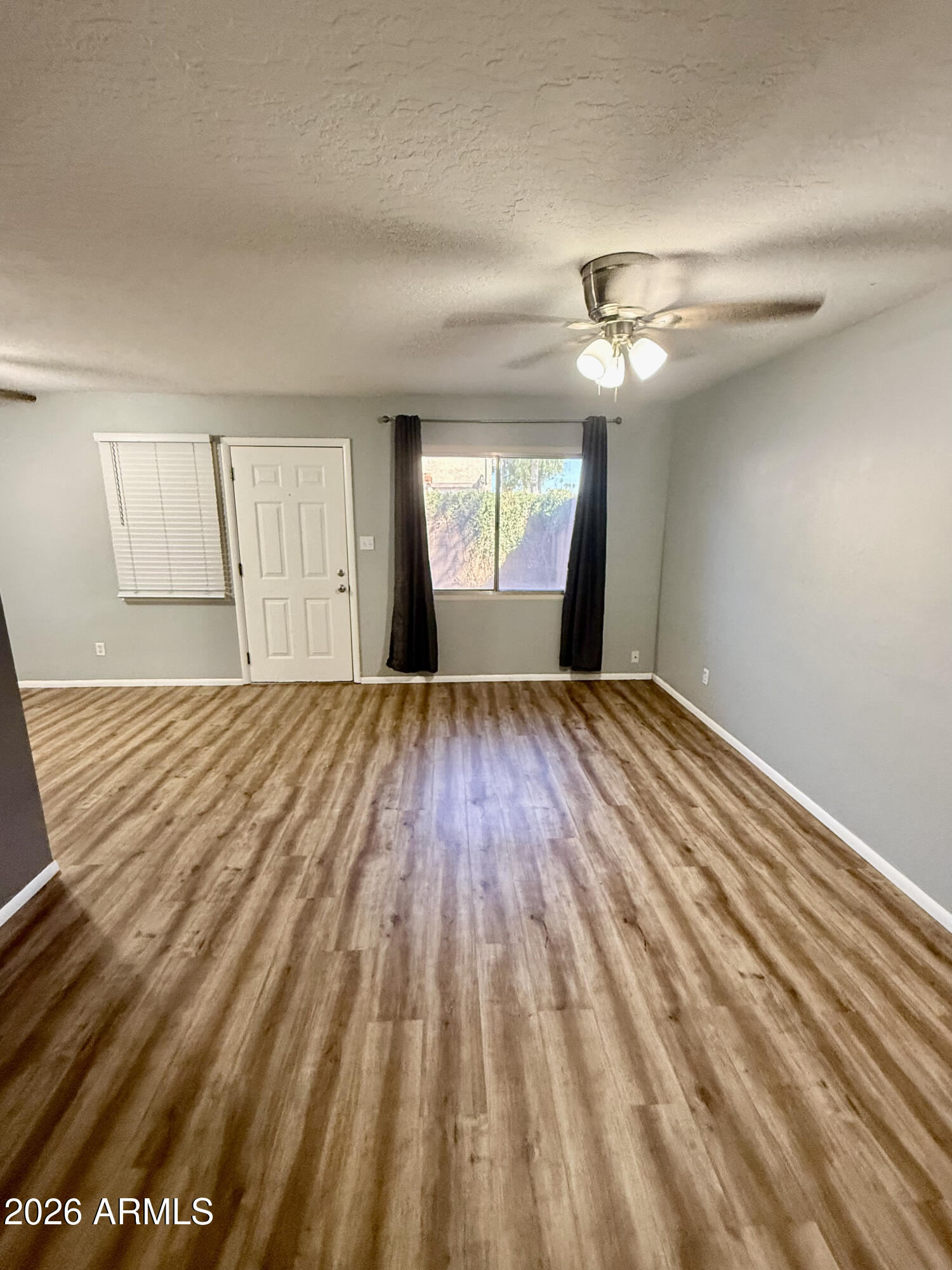 600 South Dobson Road, Unit 111 Mesa, AZ 85202 - Photo 11 of 24 a view of empty room with wooden floor and fan