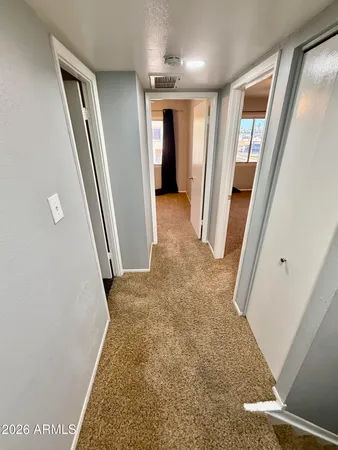 an empty room with windows and fan