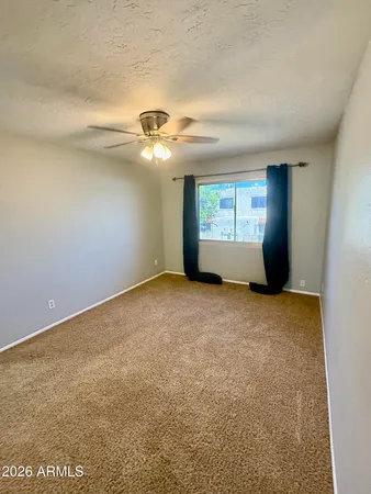 an empty room with a fan and a fan