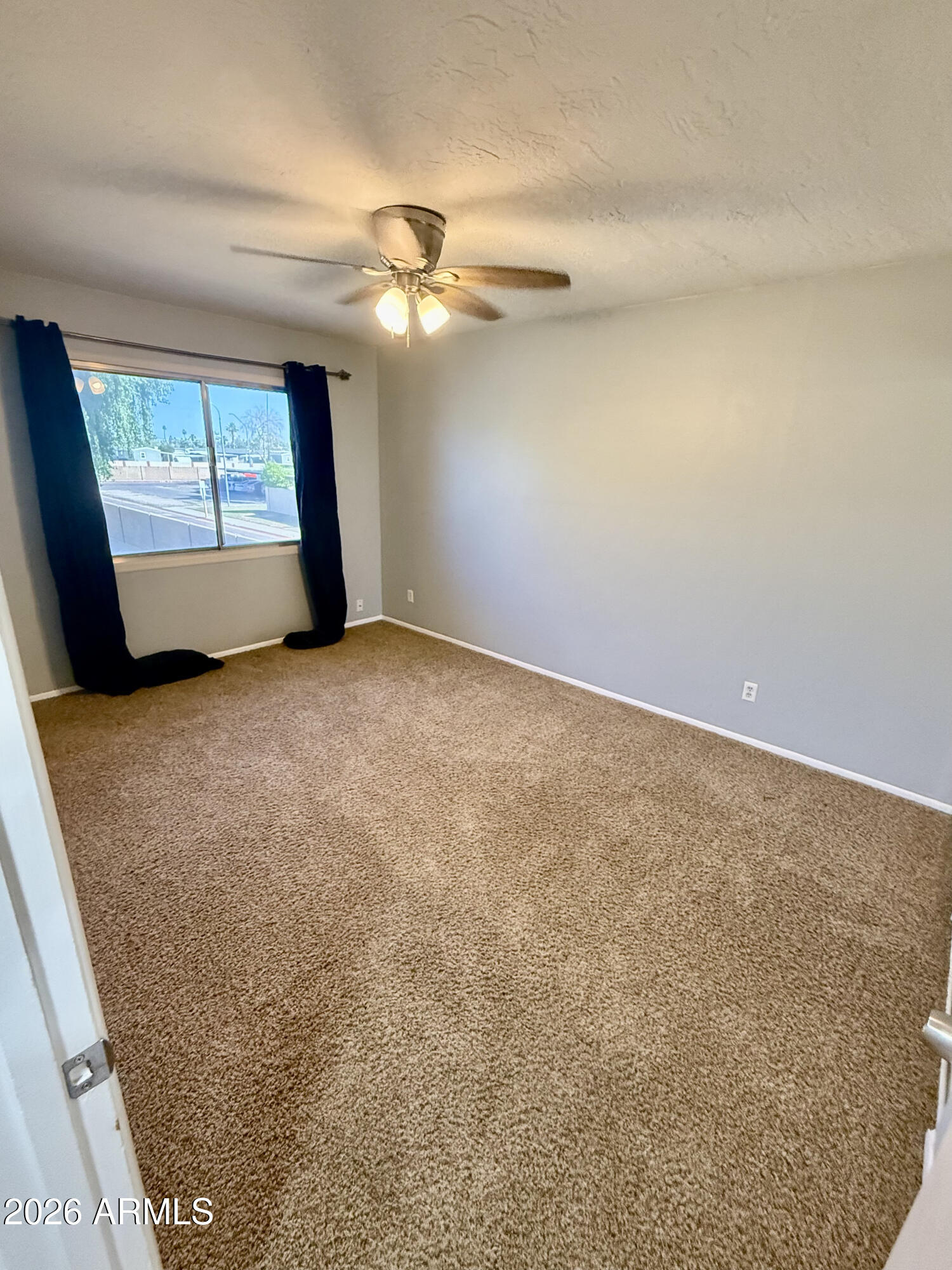 600 South Dobson Road, Unit 111 Mesa, AZ 85202 - Photo 19 of 24 an empty room with windows and fan