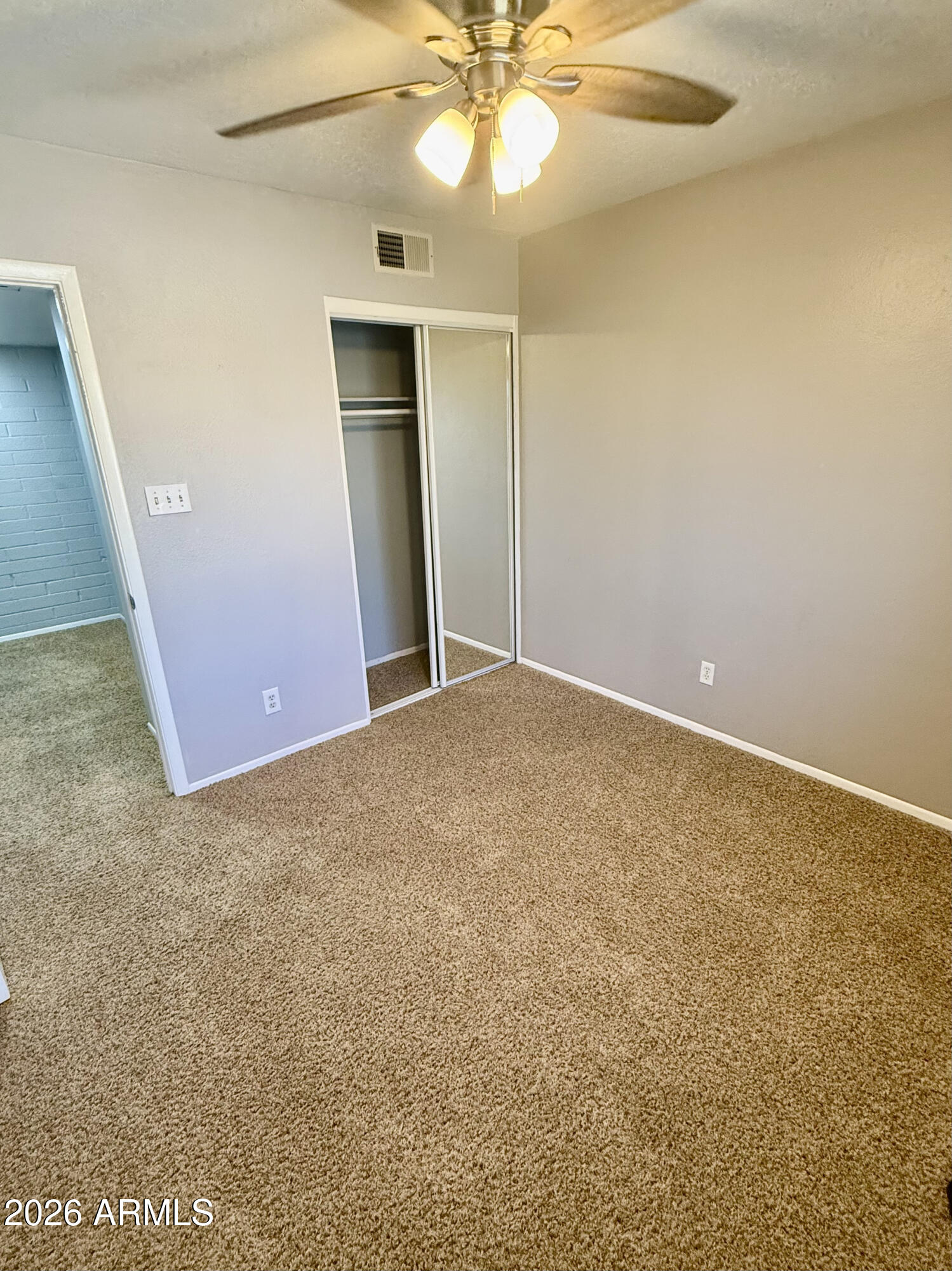 600 South Dobson Road, Unit 111 Mesa, AZ 85202 - Photo 20 of 24 an empty room with a chandelier fan and windows