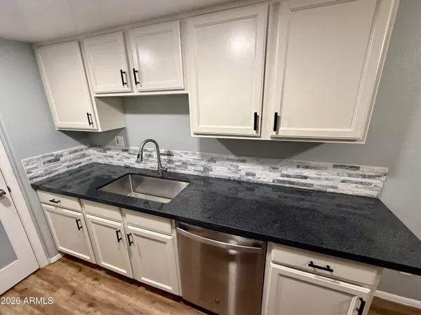 a kitchen with granite countertop a sink and cabinets