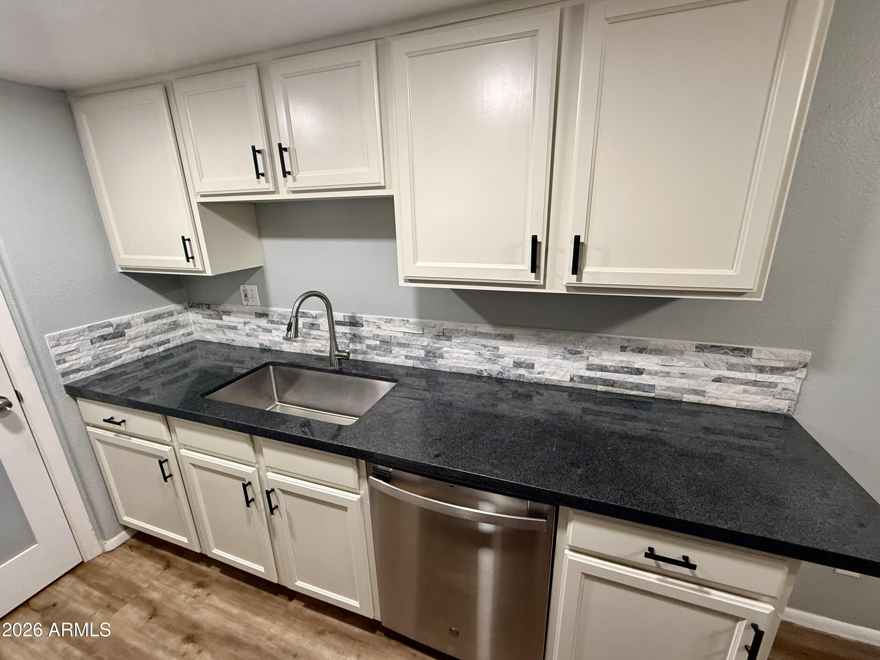600 South Dobson Road, Unit 111 Mesa, AZ 85202 - Photo 2 of 24 a kitchen with granite countertop a sink and cabinets
