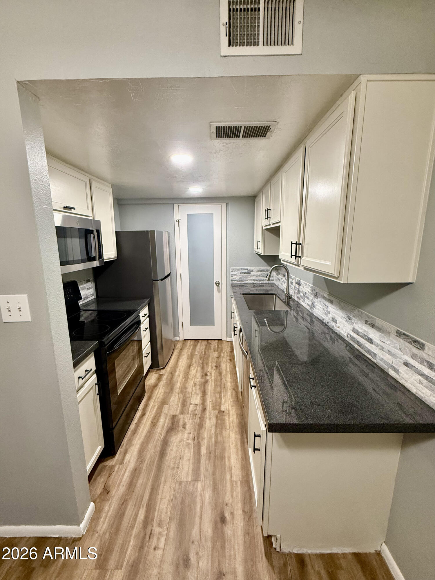 600 South Dobson Road, Unit 111 Mesa, AZ 85202 - Photo 4 of 24 a kitchen with stainless steel appliances granite countertop a sink a stove and a refrigerator