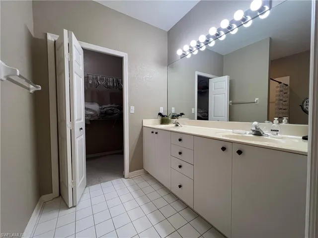 a bathroom with a double vanity sink and a mirror
