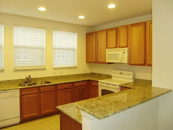 a kitchen with stainless steel appliances granite countertop wooden cabinets a sink and dishwasher