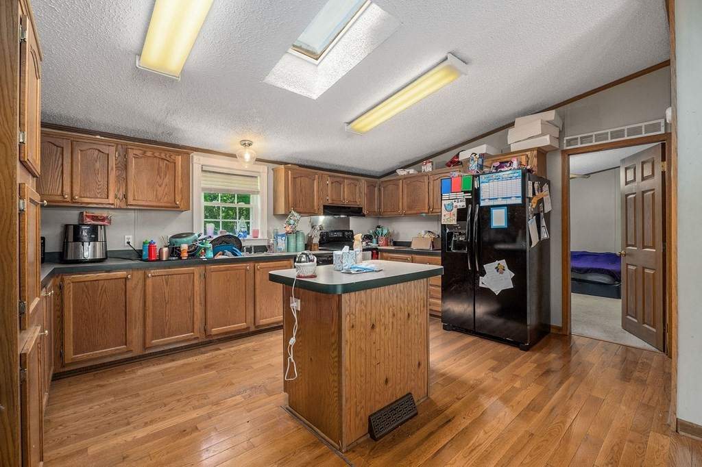 431 Mohawk Valley Road Monroe, TN 38573 - Photo 13 of 28 a kitchen with stainless steel appliances granite countertop a refrigerator a sink dishwasher a stove and a dining table with wooden floor