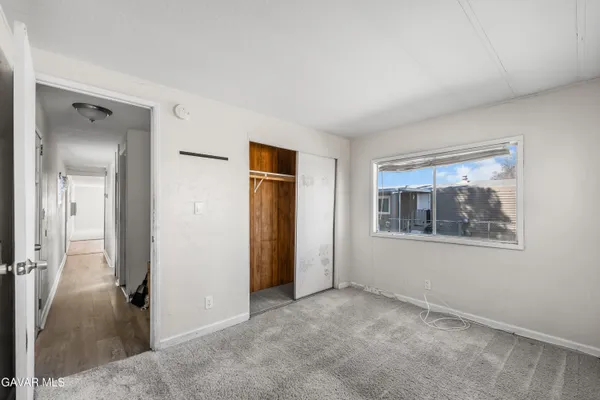 an empty room with windows and closet