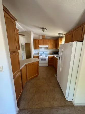 a kitchen with sink refrigerator and microwave
