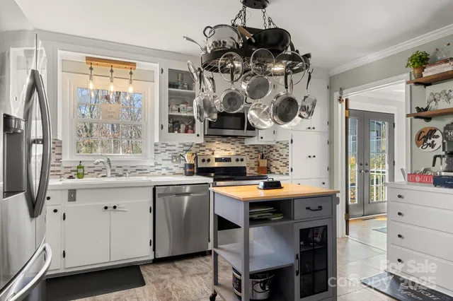 a kitchen with stainless steel appliances granite countertop a sink a stove and a wooden floor