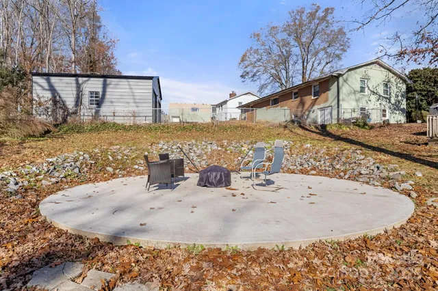a view of a house with backyard and trees