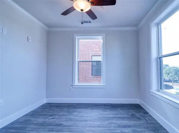 an empty room with a window and a ceiling fan