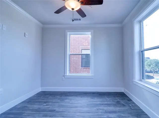an empty room with a window and a ceiling fan