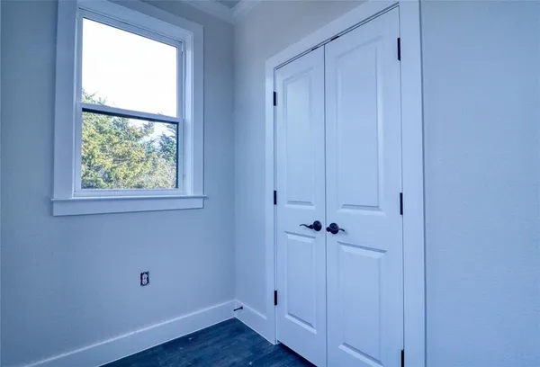an empty room with wooden floor and a window