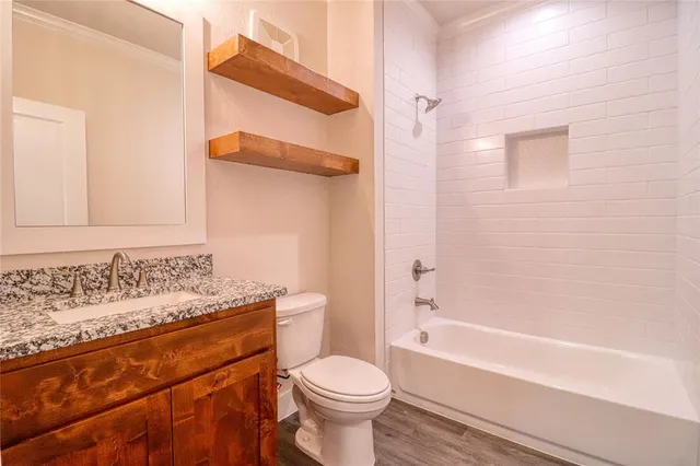 a bathroom with a sink toilet vanity and shower