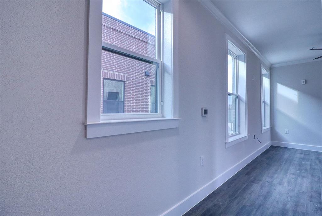 525 George Hopper Road, Unit 210 Midlothian, TX 76065 - Photo 2 of 20 a view of an empty room with wooden floor and a window