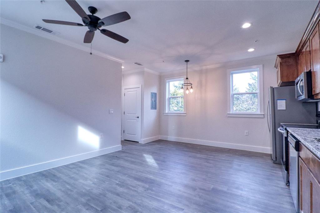 525 George Hopper Road, Unit 210 Midlothian, TX 76065 - Photo 3 of 20 a view of an empty room with a window and wooden floor