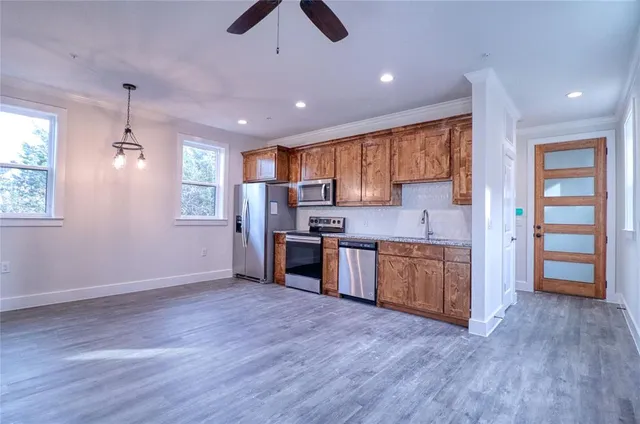 a kitchen with stainless steel appliances granite countertop a stove cabinets and wooden floor