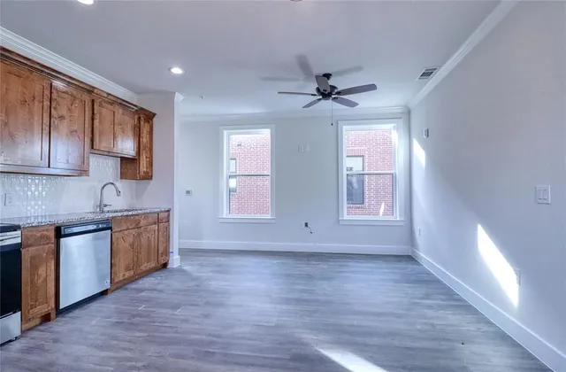 a view of a kitchen with a sink dishwasher and wooden floor