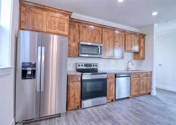 a kitchen with stainless steel appliances granite countertop a refrigerator stove top oven and sink