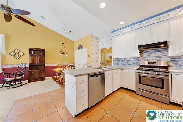 a kitchen with stainless steel appliances a stove a sink and cabinets