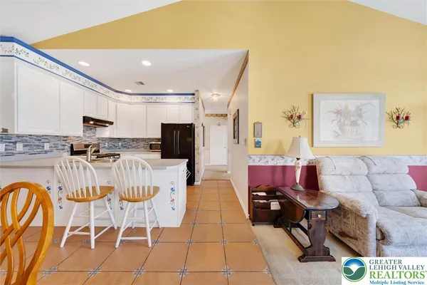 a living room with furniture a flat screen tv and kitchen view