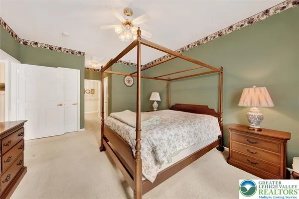a bedroom with a bed and a lamp on the dresser