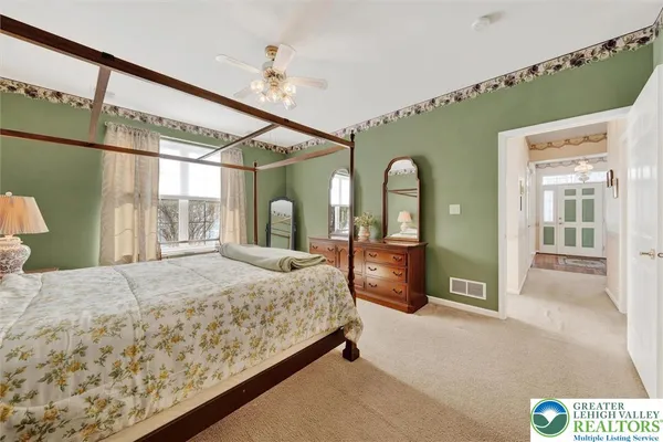a bedroom with a bed mirror and window