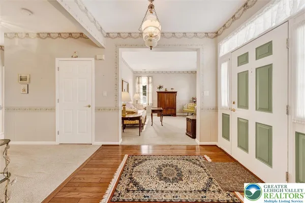 a view of a hallway to a livingroom with wooden floor and a rug