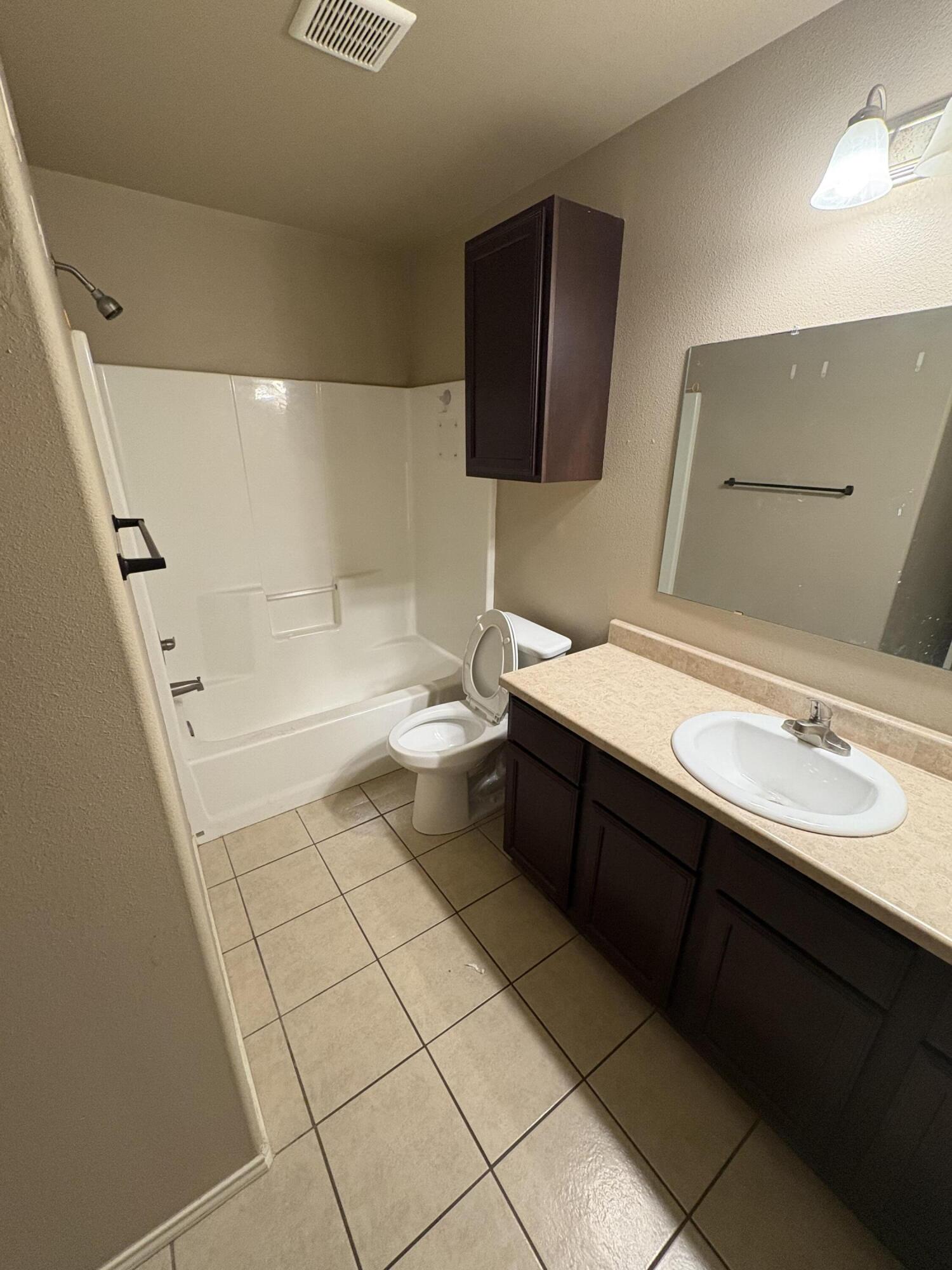 1236 Wheelock Street Lubbock, TX 79403 - Photo 13 of 17 a bathroom with a sink a toilet and a mirror