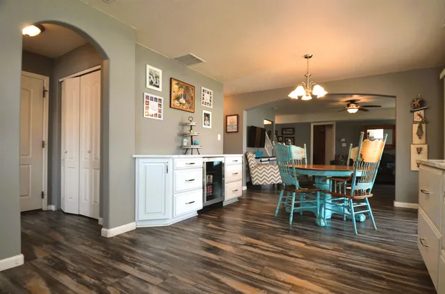 a dining room with chandelier and wooden floor