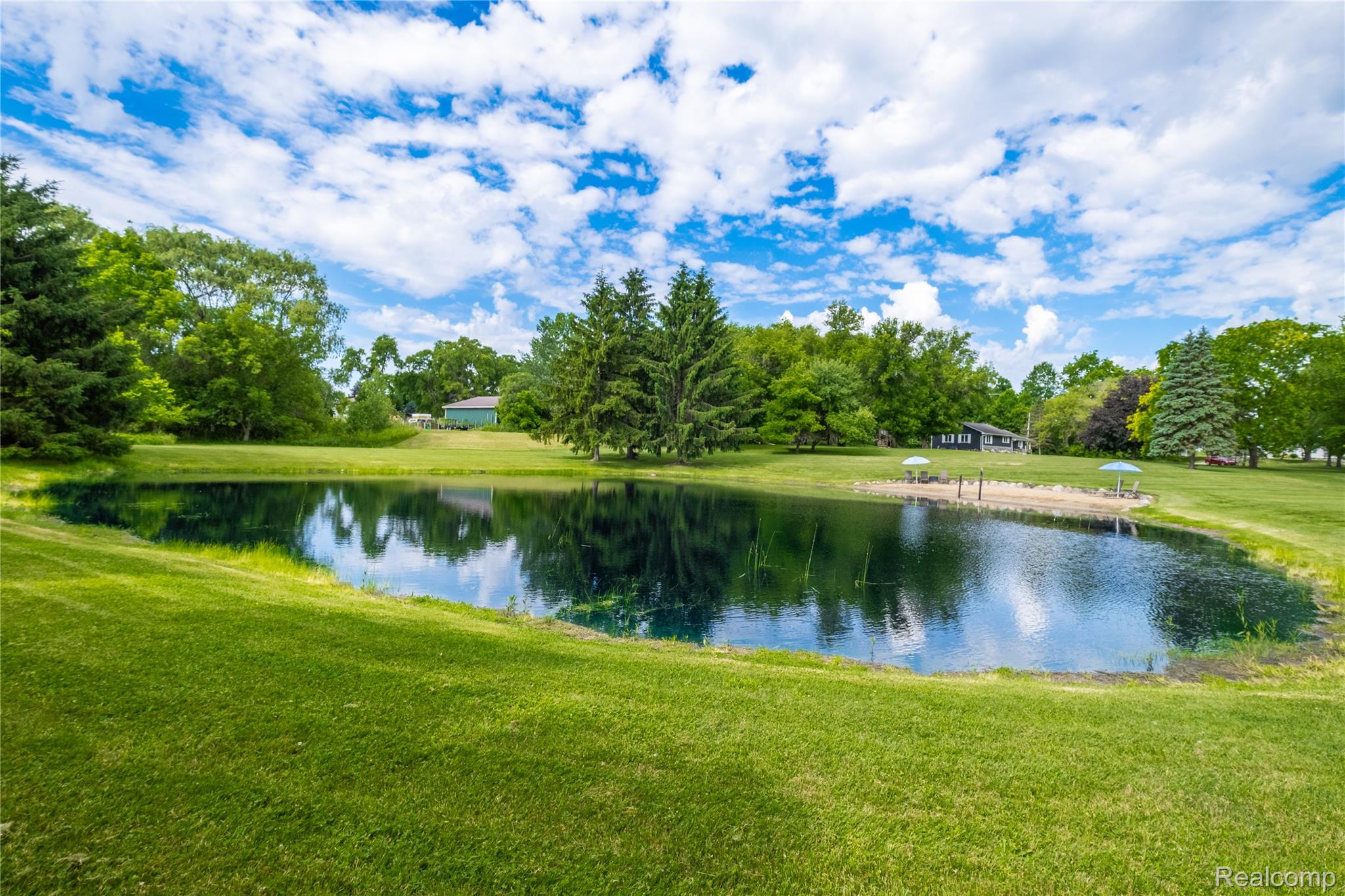 4418 North Gale Road Davison, MI 48423 - Photo 41 of 46 Private pond surrounded by expansive green lawn, mature trees, and a sandy beach area