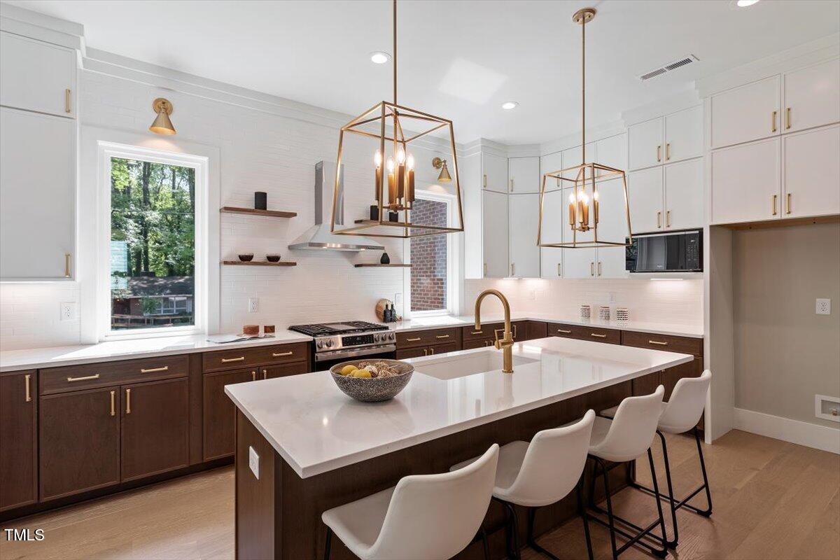 337 Merrywood Drive Raleigh, NC 27610 - Photo 12 of 52 a kitchen with a table chairs stove and microwave