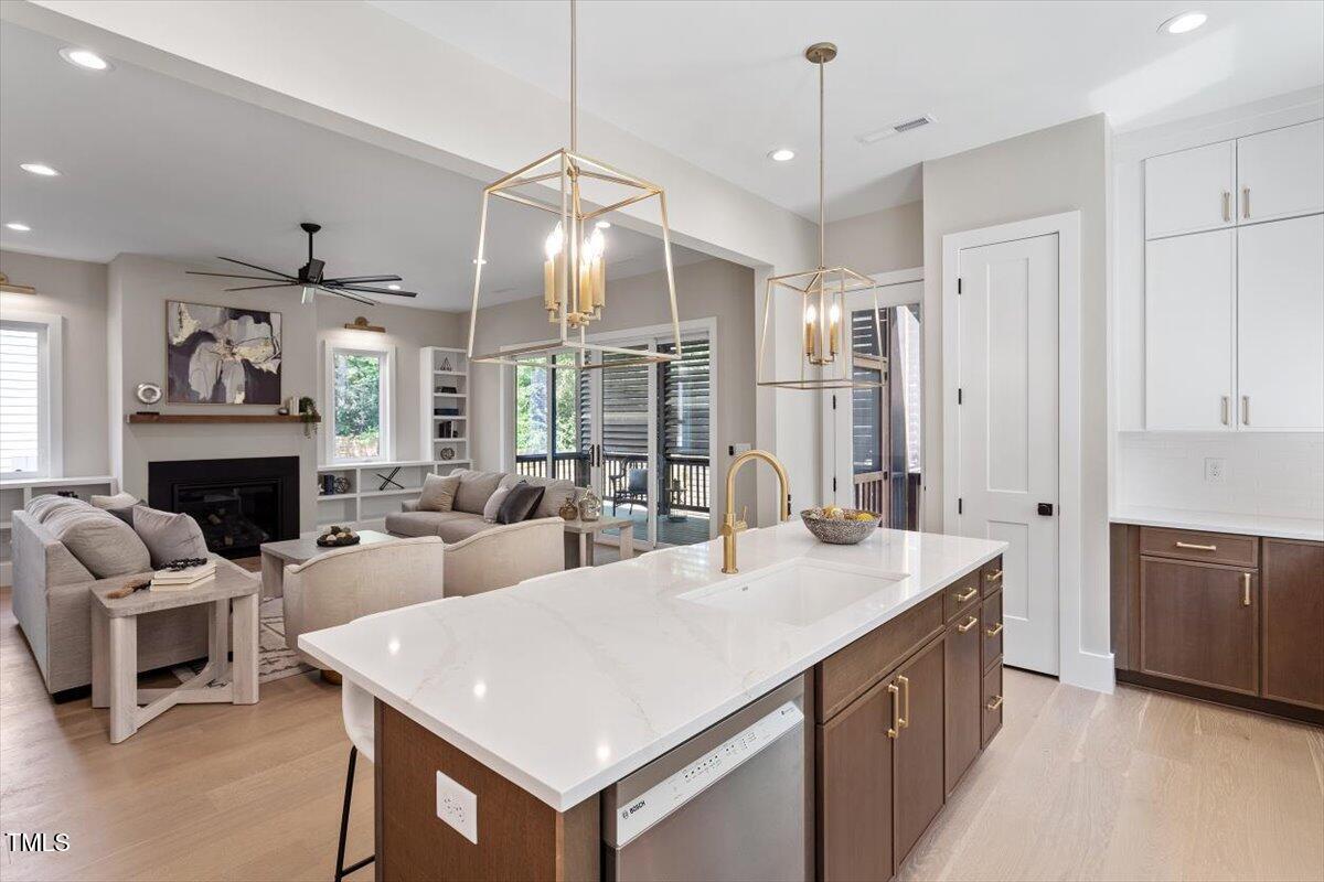 337 Merrywood Drive Raleigh, NC 27610 - Photo 18 of 52 a large living room with stainless steel appliances granite countertop furniture a fireplace a rug and a chandelier