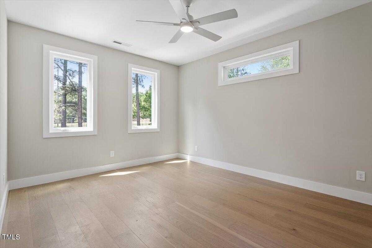 337 Merrywood Drive Raleigh, NC 27610 - Photo 28 of 52 a view of an empty room with wooden floor and a window