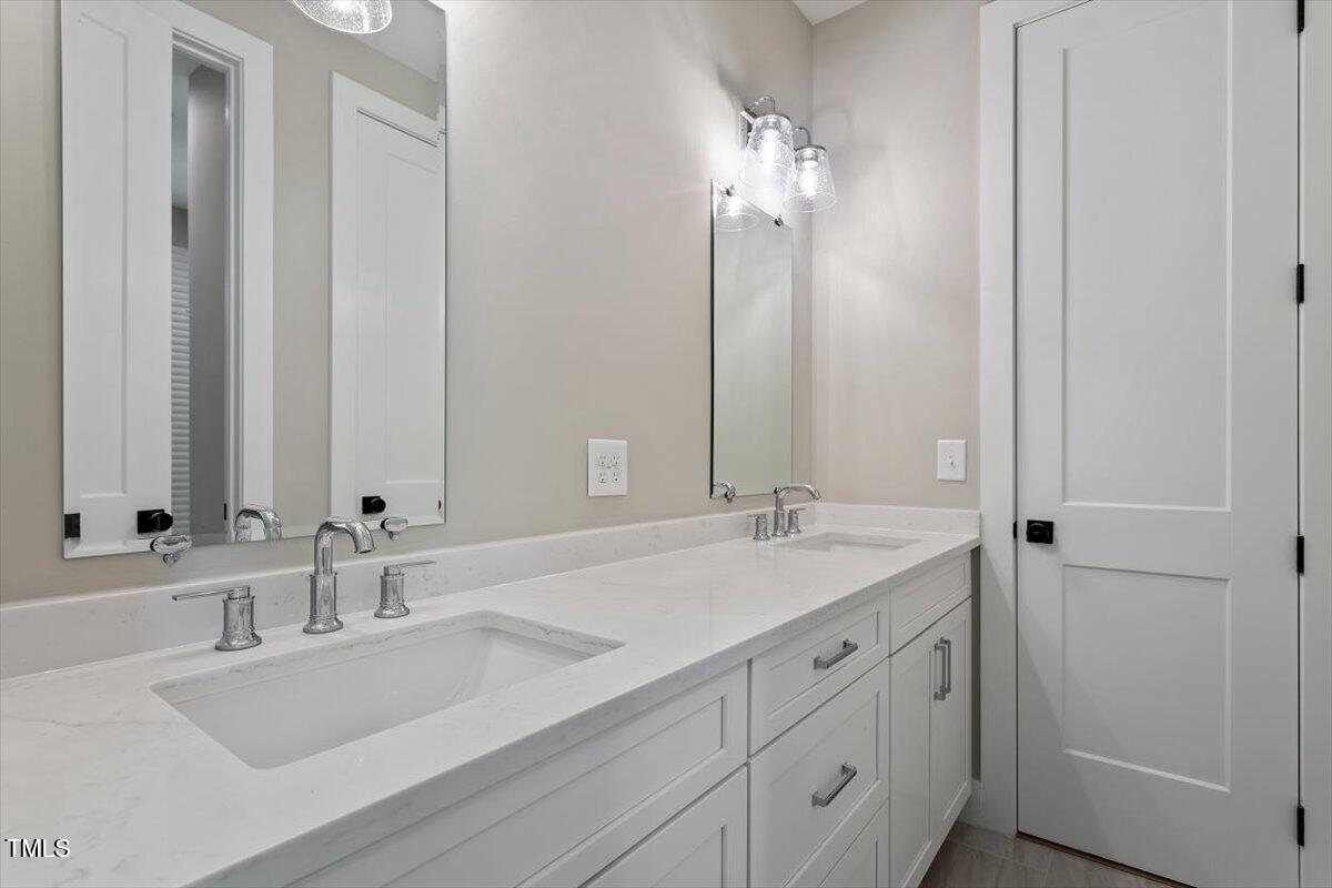 337 Merrywood Drive Raleigh, NC 27610 - Photo 30 of 52 a bathroom with double vanity sinks and a mirror