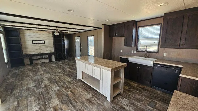 a kitchen with kitchen island granite countertop a sink stove and refrigerator
