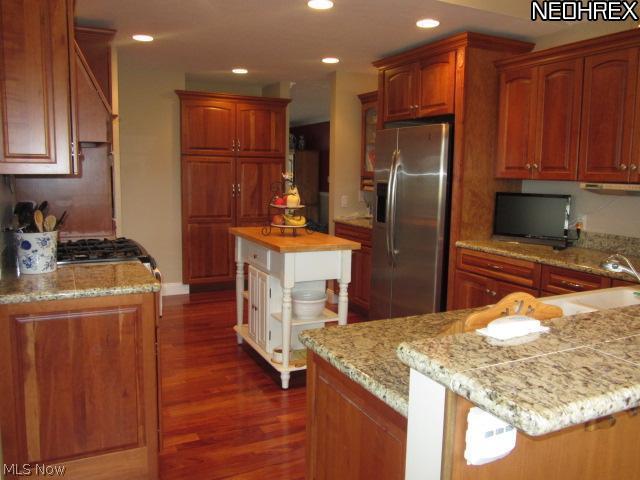 3839 Sandy Lake Road Ravenna, OH 44266 - Photo 7 of 23 The kitchen has granite, stainless steel appliances and cherry cabinets compliment the cherry floors.