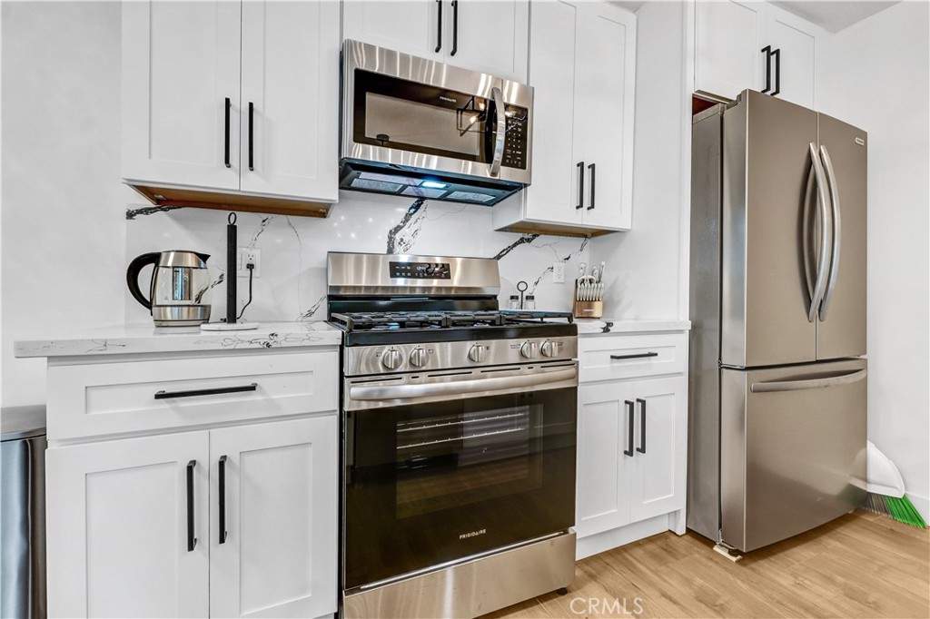 4354 Oakwood Avenue Los Angeles, CA 90004 - Photo 11 of 17 a kitchen with stainless steel appliances a stove microwave and refrigerator