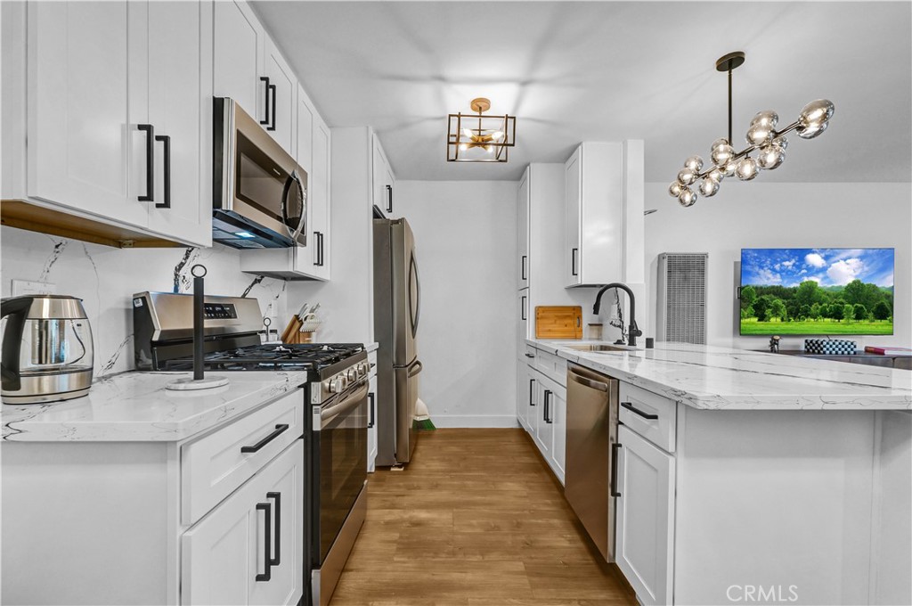 4354 Oakwood Avenue Los Angeles, CA 90004 - Photo 9 of 17 a kitchen with stainless steel appliances granite countertop a stove top oven a sink dishwasher and a refrigerator