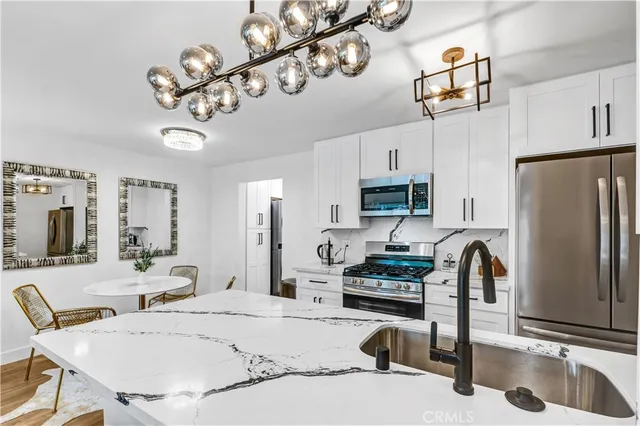 a kitchen with stainless steel appliances granite countertop a sink refrigerator stove and microwave