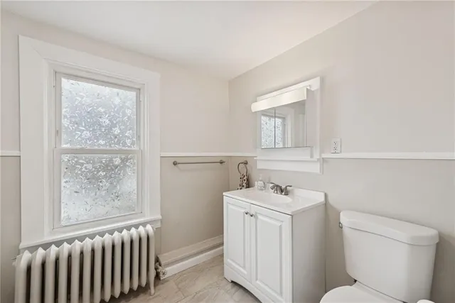 a bathroom with a sink a toilet and a window