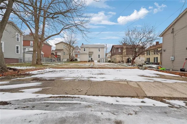 a view of a white house with a snow on the road