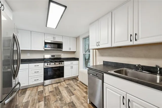 a kitchen with granite countertop a sink stainless steel appliances and cabinets
