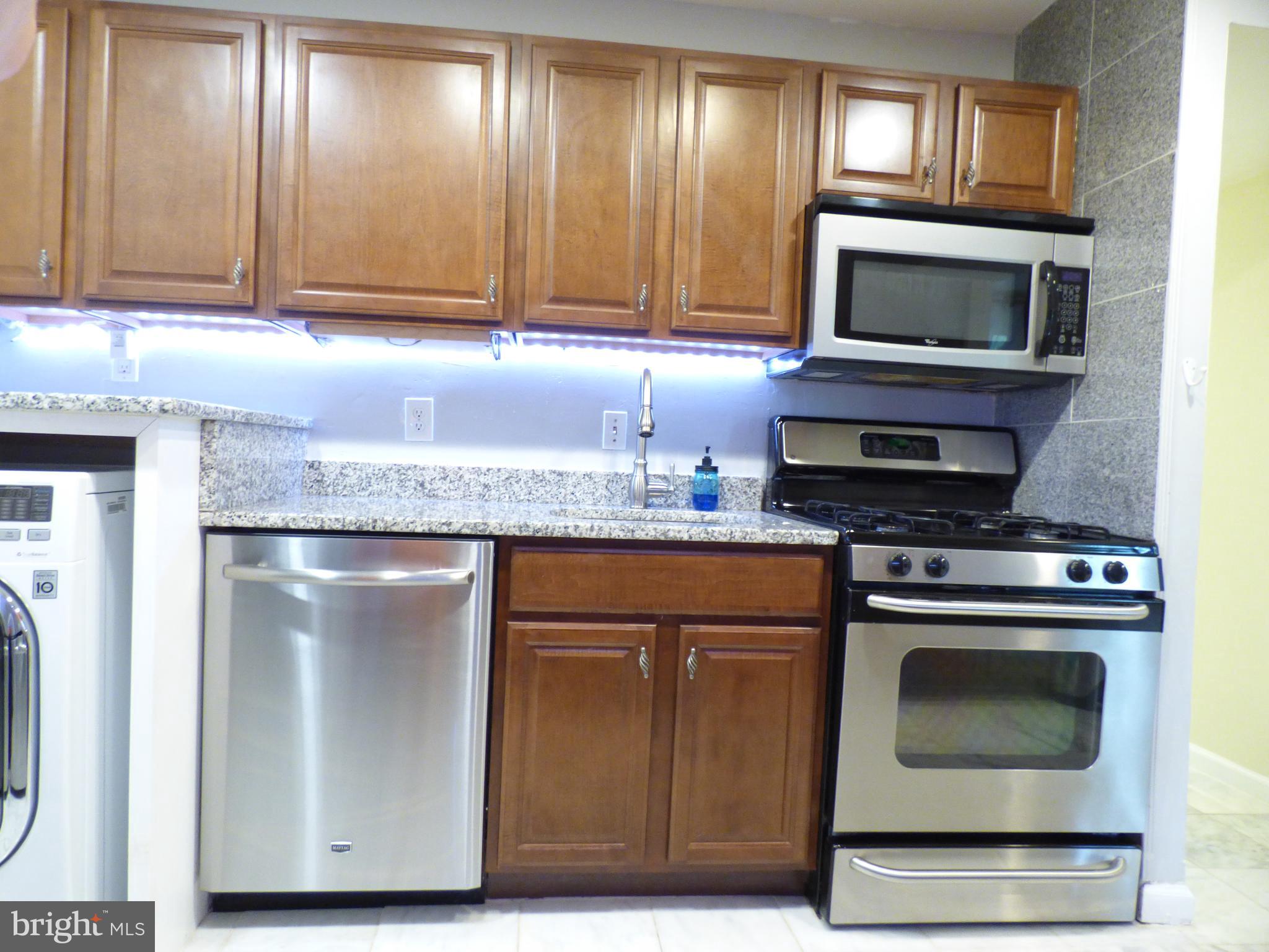 a kitchen with granite countertop a stove and a microwave